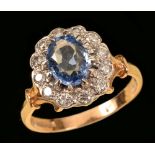 A Sapphire and Diamond Cluster Ring claw-set oval-cut sapphire within a frame of pavé-set