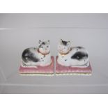 A pair of 19th Century Derby porcelain small seated Cats with black painted details on pink and gilt