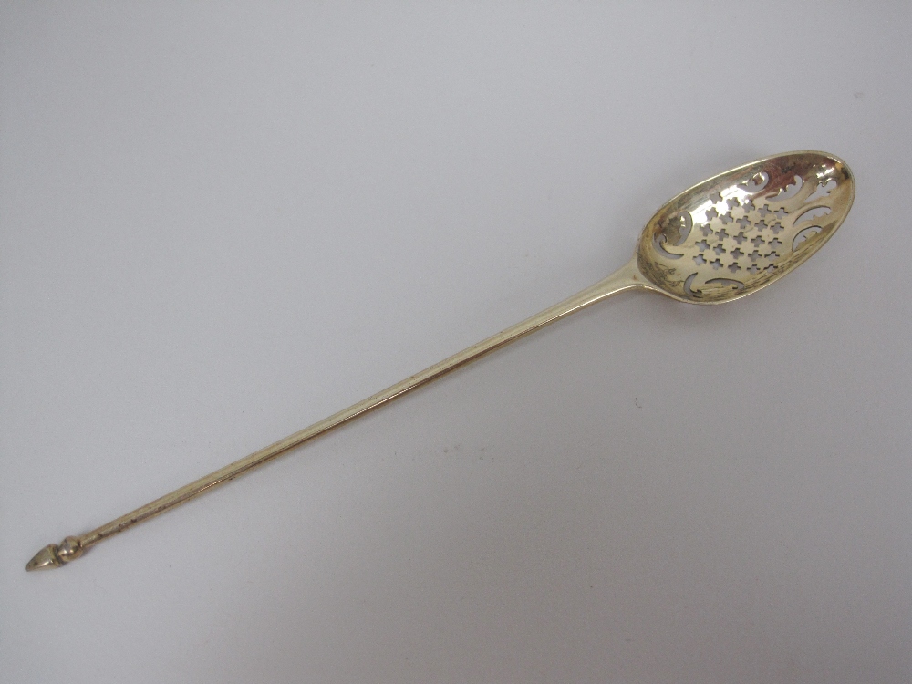 An 18th Century silver-gilt Mote Spoon with saltire cross and scroll piercing, engraved crest and