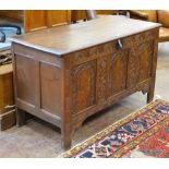 A 17th Century oak Coffer with hinged plank lid above three panel front having floral inlay and