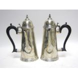 A Pair of George V silver Chocolate Pots of plain tapering form with ebonised scroll handles, London