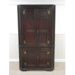 An 18th Century oak Double Corner Cupboard with two pairs of solid panelled doors having brass H