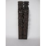 A pair of 17th Century carved oak Pilasters with bearded figures above flowers and scrolls, 21in