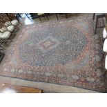 A bordered Persian Carpet with shaped floral medallion and corner design on a blue ground, the