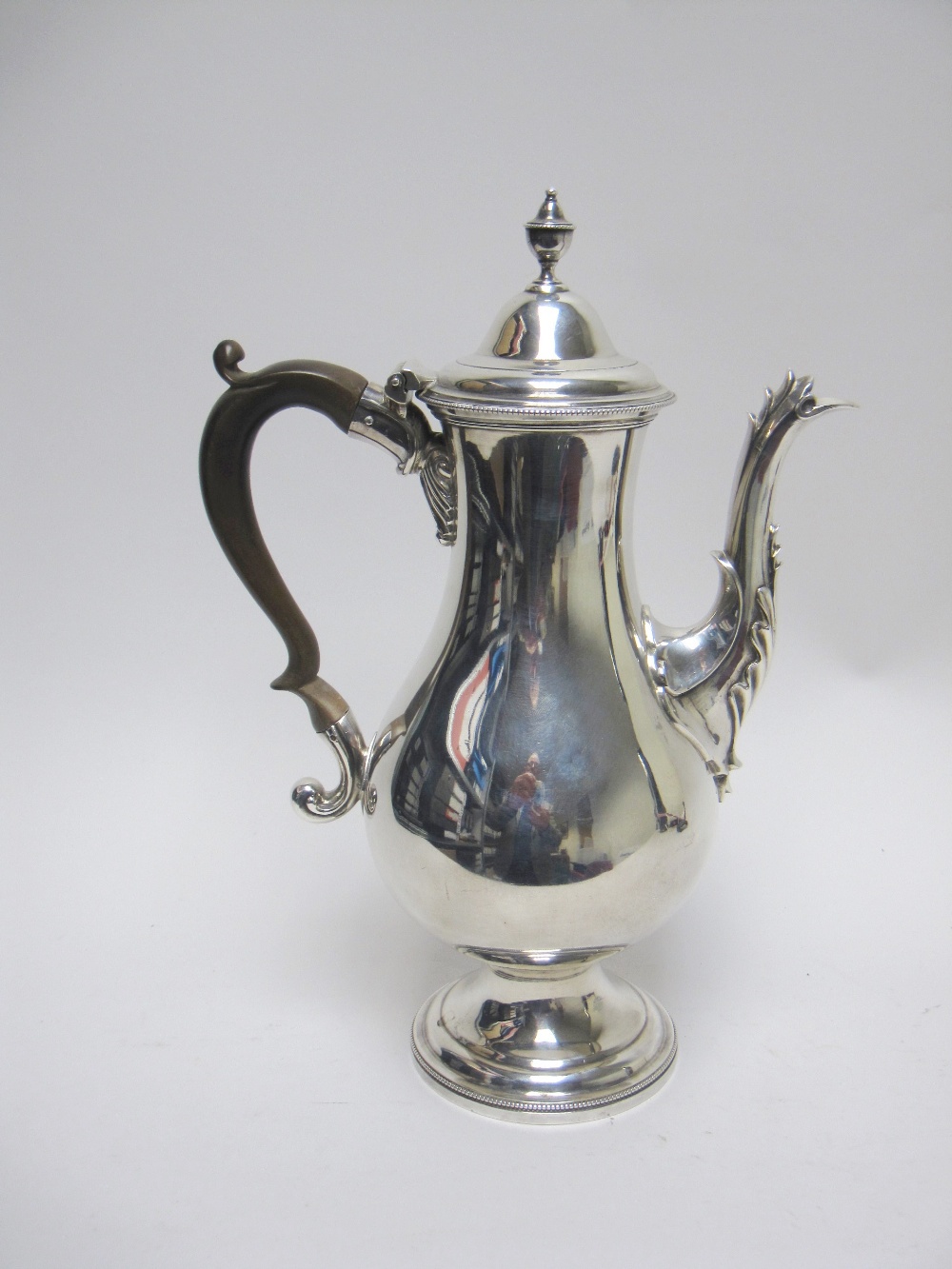 A George III silver Coffee Pot of baluster form, the domed lid with urn finial, ornate spout, scroll