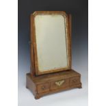 An 18th Century walnut Toilet Mirror, the moulded frame within a pair of angled uprights, above a