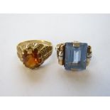 A Topaz Ring claw-set oval-cut stone stamped 750, ring size N, and a Dress Ring set step-cut blue