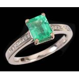 An Emerald and Diamond Ring corner claw-set step-cut emerald, 1.18cts, with graduated princess-cut