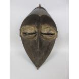 A Lwalwa Mask, wood, blackish-brown stain with traces of white pigment, Congo
