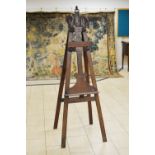 A mahogany Easel, the upper section of the front supports carved as swan's heads and also with