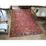 A Persian Carpet with multi-border design and having stylised floral motifs on a red ground, 11ft