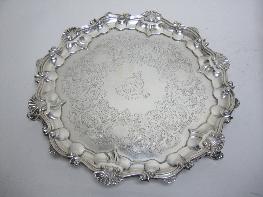 A Victorian silver shaped circular Salver with floral scroll engraving, coat of arms, scallop border