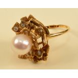 A Cultured Pearl and Diamond Cocktail Ring set central pearl within frame of square petals, some