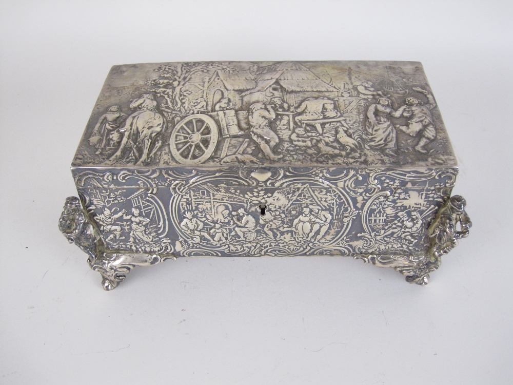 A Continental silver Casket embossed with figures merrymaking, cast figure musicians to the corners,