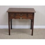 An 18th Century oak Lowboy with cross-banded top above three cross-banded short drawers and shaped