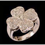 A Diamond Clover Ring claw-set brilliant-cut stone within four petals pavé-set numerous smaller