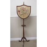 A 19th Century painted satinwood Pole Screen with shield shaped needlework panel on tripod base, 5ft