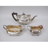 A George III silver three piece Tea Service of boat shape with gadroon embossing on bun feet, London