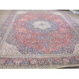 A bordered Persian Carpet with floral medallion and corner design on a red and blue ground, the main