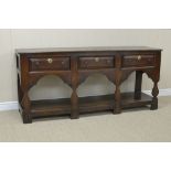 An early 18th Century oak Dresser Base fitted three drawers above shaped frieze on silhouette