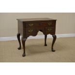 An antique oak Lowboy fitted one long and two short drawers around a shaped apron on four cabriole