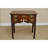 A George III mahogany Lowboy fitted one long and two short drawers around a pierced and shaped