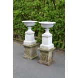 A pair of cast iron Garden Urns on square section three tier composition base, 53in