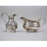 A George IV silver Milk Jug with egg and dart rim, floral engraved frieze on ball feet, London 1823,