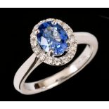 A Sapphire and Diamond Cluster Ring claw-set oval-cut sapphire, 1.33cts, within a frame of pavé-