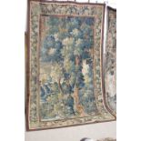 An 18th Century Flemish Verdure Tapestry of a wooded landscape with trees and a village in the