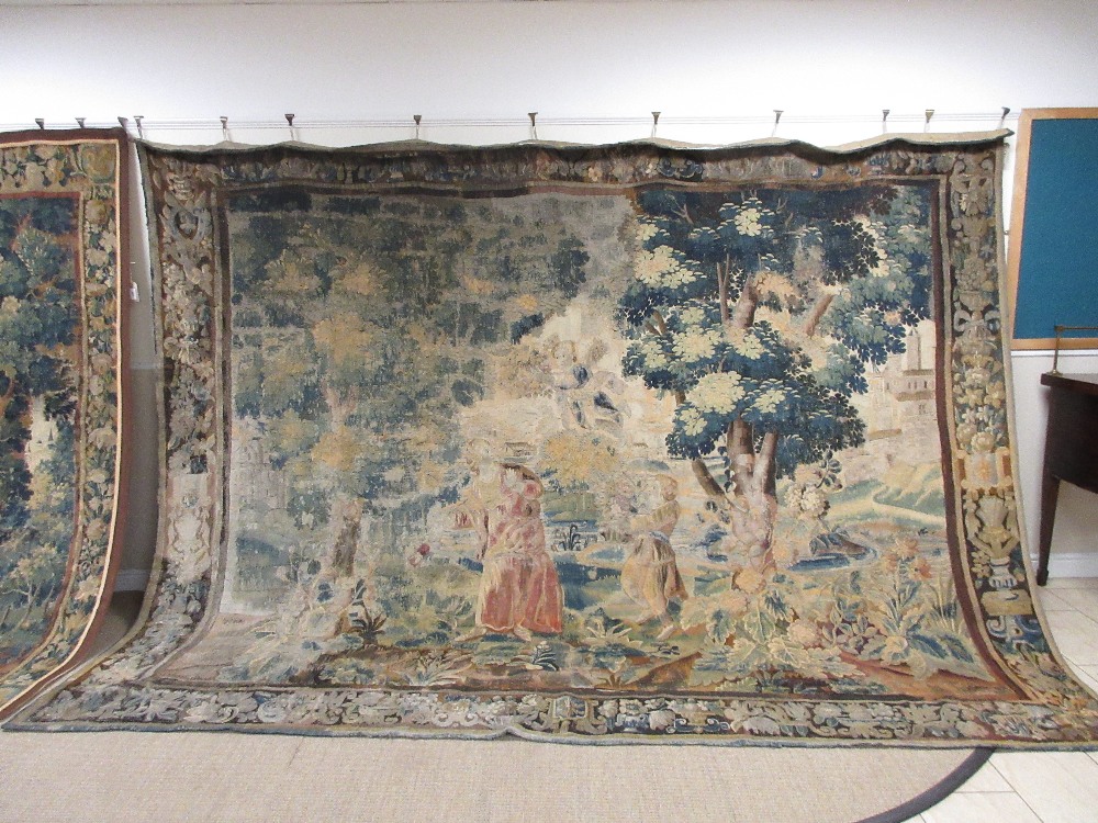 A 17th Century Flemish Verdure Tapestry of figures in an extensive landscape of trees and shrubs