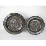 An antique brass Alms Dish embossed Adam and Eve, 14in, and another, gadroon embossed, 16in