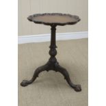 A Chippendale design Wine Table with well carved pie crust top on turned and fluted column, carved