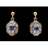 A pair of Sapphire and Diamond Earrings each claw-set lozenge-cut sapphire within frame of