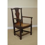 An 18th Century oak Elbow Chair with shaped solid splat, solid seat on square front legs