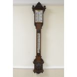 A Victorian large Stick Barometer and Thermometer in carved oak case