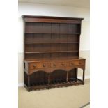 A late 18th Century oak Dresser and Shelves, the boarded rack over three short drawers, shaped apron