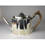 A George III silver Teapot of oval panelled form with wooden handle and finial, London 1792,