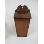 An antique oak Salt Box with shaped surmount, sloping lid above cross-banded base, 17in