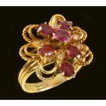 A Ruby and Diamond Flower Cluster Ring the openwork plaque claw-set six oval-cut rubies and leaves