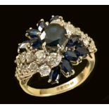 A Sapphire and Diamond Cocktail Ring claw-set round sapphire in crossover mount surrounded by