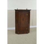 An 18th Century walnut Corner Cupboard with surface fret carved frieze above raised panel door