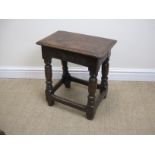 A 17th Century oak Joint Stool with moulded top above arch carved frieze on baluster turned and