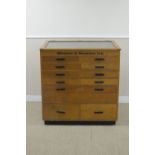 An oak Winsor and Newton Artist's Cabinet with sloping glazed lid above ten short drawers, fall