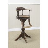 A 19th Century Child's Barbers Revolving Chair with cane seat, footrest on turned column and