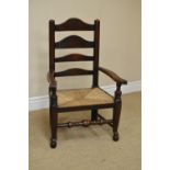 A 19th Century Child's Elbow Chair with ladderback, rush seat on turned front legs and pad feet