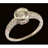 A Diamond Ring millegrain-set old-cut stone with smaller stones to shoulders in carved mount, ring