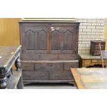 An 18th Century squat Linen Press fitted with a pair of cupid's bow panelled doors above base fitted