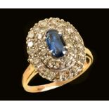 A Sapphire and Diamond Cluster Ring claw-set oval-cut sapphire within double frame of brilliant-