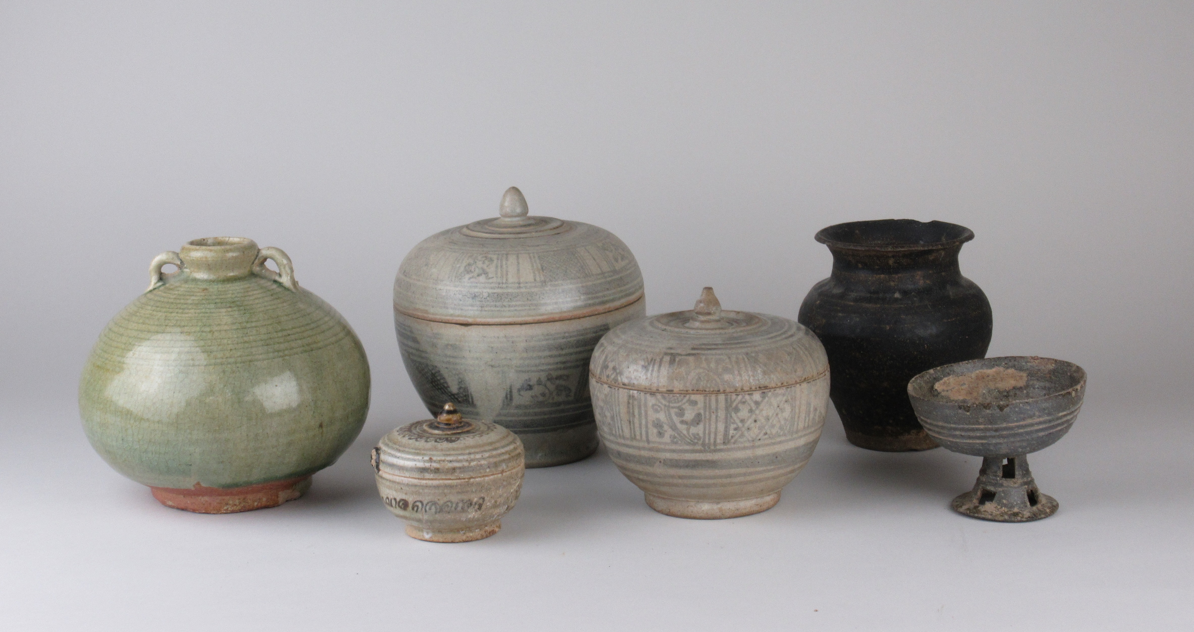 Six Thai pottery Vessels, including three 15th Century Swankalok Jars and Covers, a celadon globular